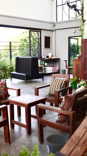 a living room filled with wooden furniture and windows at Nornlamphun Boutique Hotel นอนลำพูน in Lamphun