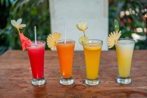 un gruppo di quattro bevande di colore diverse su un tavolo di Ina Inn ad Ubud
