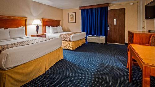 a hotel room with two beds and a desk at Hotel Pentagon in Arlington
