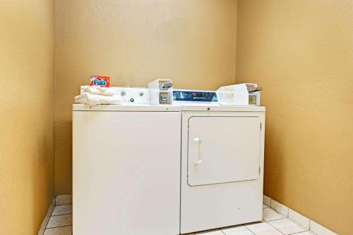 a small white refrigerator in a corner of a room at SureStay Plus by Best Western San Antonio Airport in San Antonio