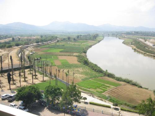 a view of a river with palm trees and a city at Indochine Hotel in Kon Tum