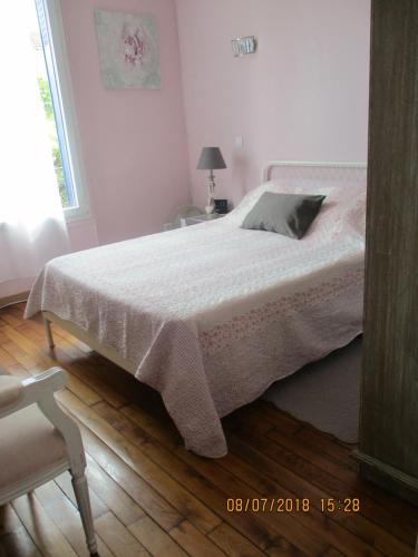 a bedroom with a bed and a chair and a window at Côté Marne in Champigny-sur-Marne