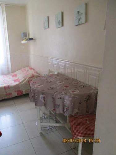 a room with a table and a bed in it at Côté Marne in Champigny-sur-Marne