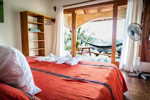 a bedroom with a red bed with a large window at Casa Andalucia in San Juan del Sur