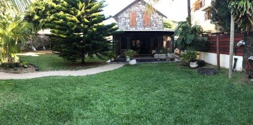 a yard with a house with a tree in it at La grange de G. in Grand Gaube