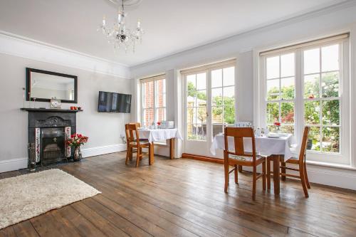 a dining room with a table and chairs and windows at Alton House Sheringham in Sheringham