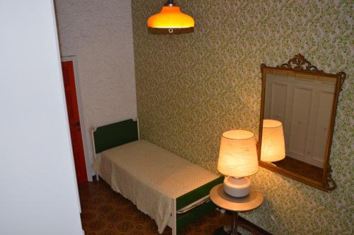 a bedroom with a bed and a mirror and a lamp at B&B VILLA LUPIDI in Corridonia