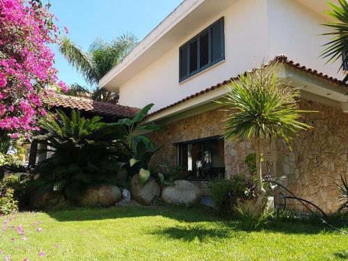 a house with palm trees in the yard at B&B Il Resort Dell'Artista in Venetico