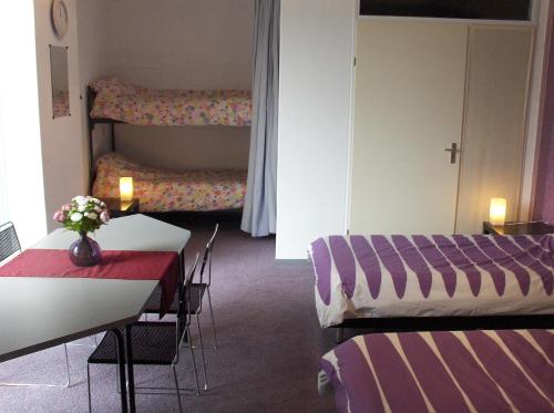 a room with two beds and a table and chairs at B&B Zevenkamp in Rotterdam