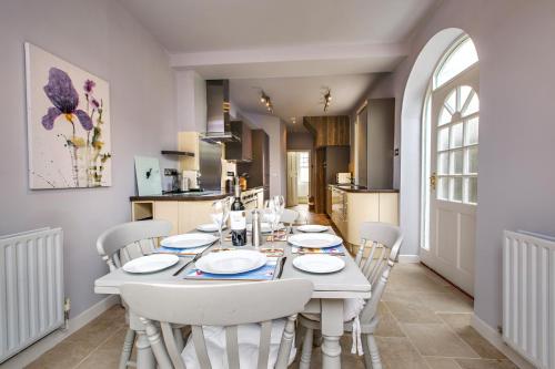 a white dining room with a white table and chairs at Alton House - The Annexe in Sheringham
