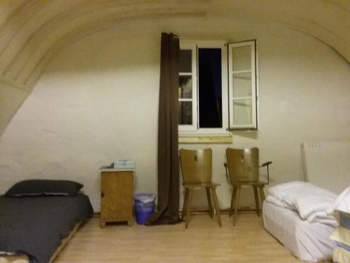a bedroom with two chairs and a bed and a window at Refugium Thanatcha in Reil