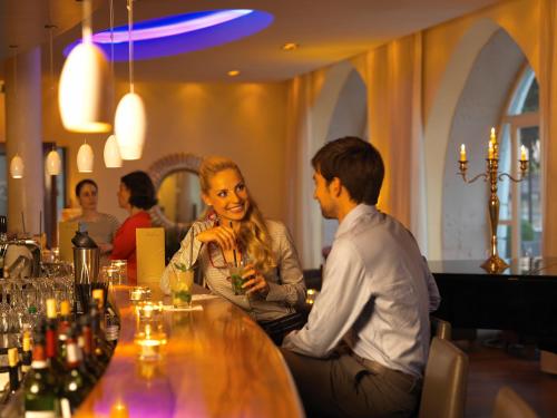 a man and woman sitting at a table in a bar at Hotel des Balances in Lucerne