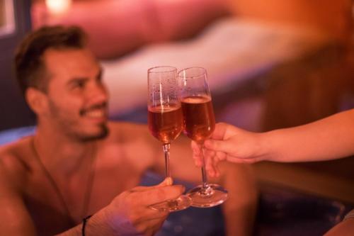 two people holding up glasses of wine at Lake Spirit Boutique Hotel & Spa in Ioannina