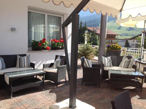 a patio with chairs and tables and an umbrella at Hotel Antines in La Villa