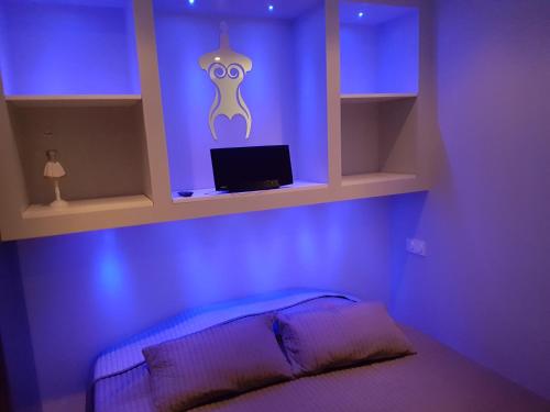 a bedroom with purple lighting and a bed with a monitor at CapSexy Port Nature Marina Naturist Village in Cap d'Agde