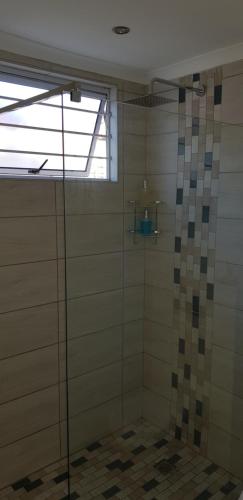 eine Dusche mit einer Glastür in einem Badezimmer in der Unterkunft The Studio on Balmoral in Durban