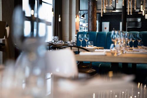 a row of tables in a restaurant with wine glasses at Hôtel Les Deux Girafes in Paris