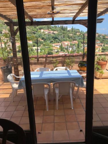 - une vue sur une table et des chaises depuis la terrasse dans l'établissement Appartements La Fossette plage, au Lavandou