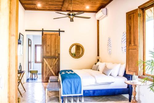 a bedroom with a bed and a ceiling fan at Villa Pulau Cinta Boutique Suites in Gili Meno