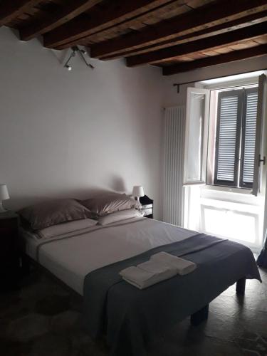 a bedroom with a large bed with a window at B&B Castellani in Pavia