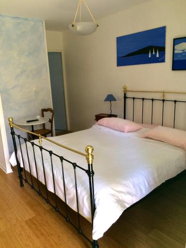 a bedroom with a large bed with white sheets at La Ferme de Thoudiere in Saint-Étienne-de-Saint-Geoirs