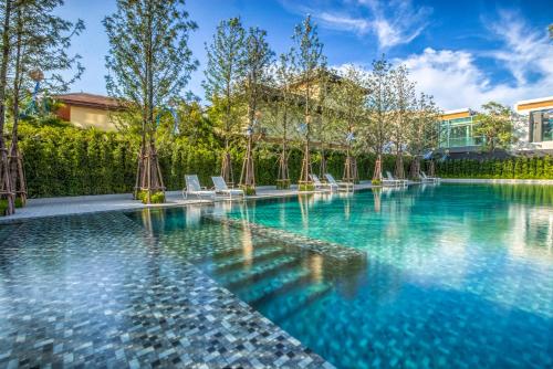 una piscina con acqua blu in un cortile di Veranda Pattaya by Lux a Jomtien Beach