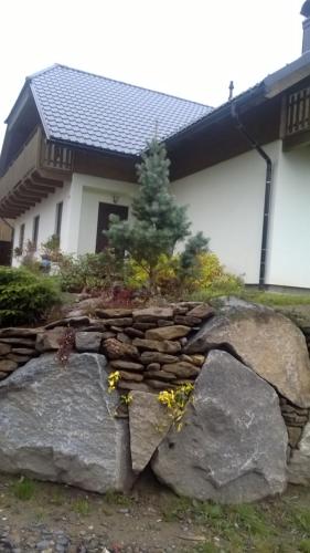 a rock garden in front of a house at Apartmány Brevant in Železná Ruda
