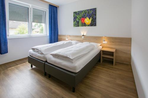 duże łóżko w pokoju z oknem w obiekcie Hotel Rimo w mieście Ort im Innkreis