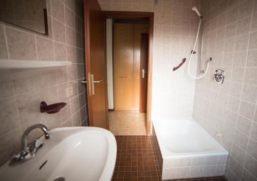 ein Bad mit einer Badewanne, einem Waschbecken und einer Dusche in der Unterkunft Ferienhaus Vulkaneifel Kopp in Kopp