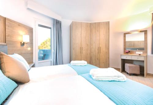 a bedroom with two beds with towels on them at Eurovillage Achilleas Hotel in Mastichari