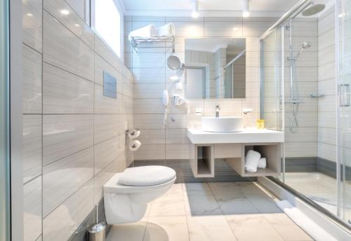 a bathroom with a toilet and a sink and a shower at Eurovillage Achilleas Hotel in Mastichari