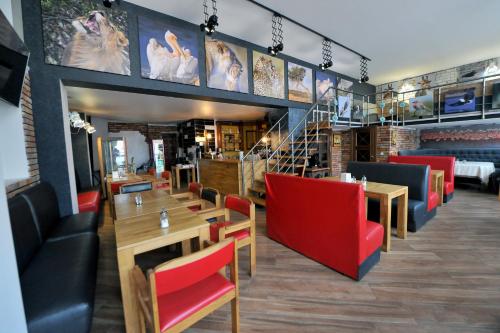 a restaurant with wooden tables and red chairs at Fontan in Chornomorsk