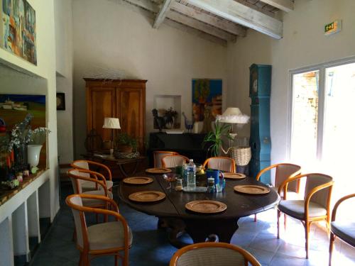 a dining room with a table and chairs at La Ferme de Thoudiere in Saint-Étienne-de-Saint-Geoirs