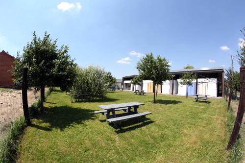 a picnic table in a park with trees and a building at La Ligule in Mignault