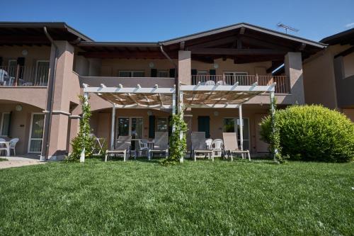 a patio with chairs and tables in front of a building at Villaggio Turistico Lugana Marina in Sirmione