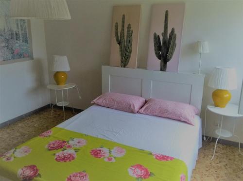 1 dormitorio con 1 cama con sábanas rosas y verdes en Residenza Agapanthus, en  Monvalle 