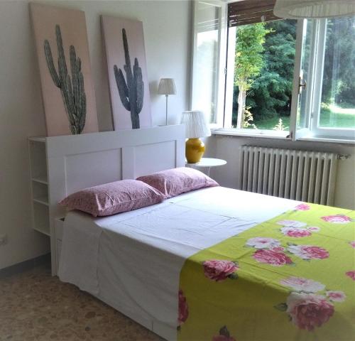 een slaapkamer met een bed met een bloemendeken bij Residenza Agapanthus in  Monvalle 