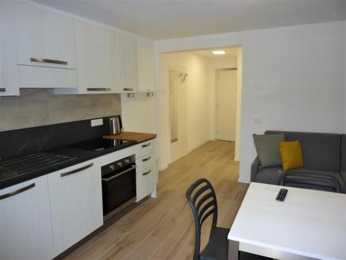 a kitchen and living room with a couch and a table at Trentino Apartments - Casa ai Tolleri in Folgaria