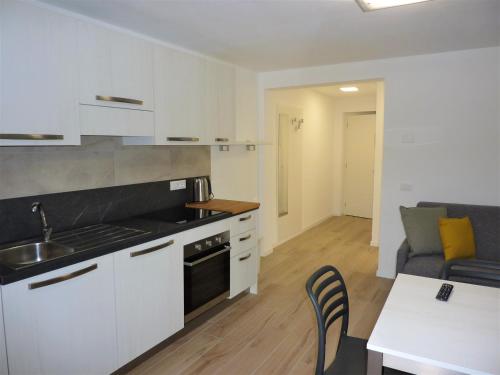 a kitchen and living room with a couch and a table at Trentino Apartments - Casa ai Tolleri in Folgaria