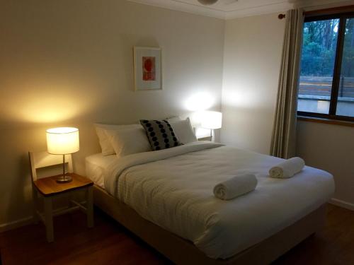 1 dormitorio con 1 cama con 2 lámparas y una ventana en Wild Woods at Pokolbin en Pokolbin