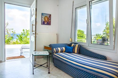 a living room with a couch and large windows at Seaview dreams in Ormos Panagias