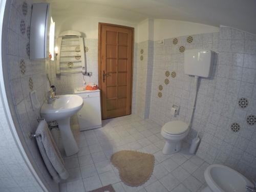 a bathroom with a toilet and a sink and a toilet istg at B&B A Casa di Sara in Pescantina