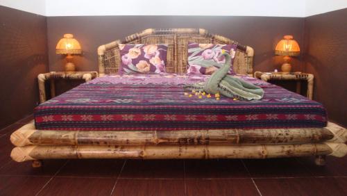 Un dormitorio con una cama hecha de troncos en Relaxing Homestay, en Kuta Lombok