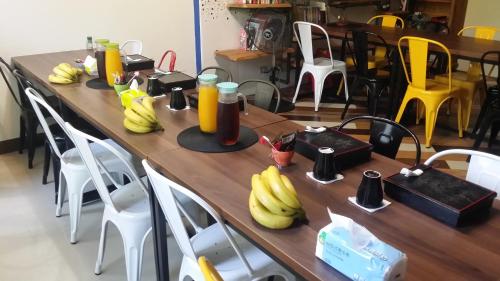 a long wooden table with bananas on it at 臺東火車站 黎亞兒民宿Liyar House 青旅客棧 in Taitung City