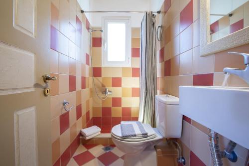 a colorful bathroom with a toilet and a window at Villa Niriides in Lefkada Town