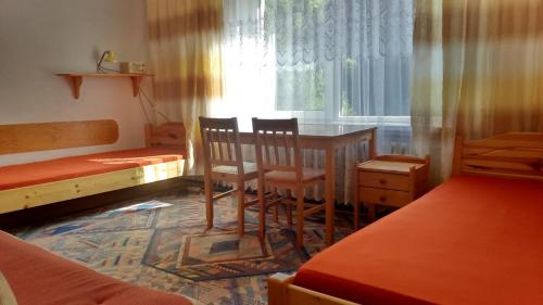 a room with a table and chairs and a window at Domlesny in Kiczora