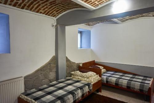 a bedroom with two beds in a room with a ceiling at Sleep&Go in Lviv