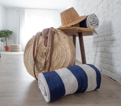 a pair of blue and white striped towels and a basket at Cliper Apartments by Escampa Hotels in Platja  d'Aro