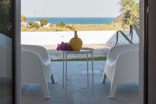 a table with a vase on top of it next to two chairs at Agriturismo Giorgio in Mattinata