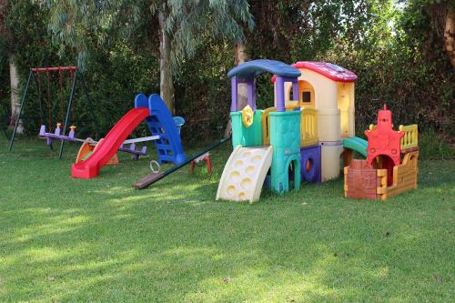 a group of childrens playground equipment in the grass at Primavera Hotel in Dassia